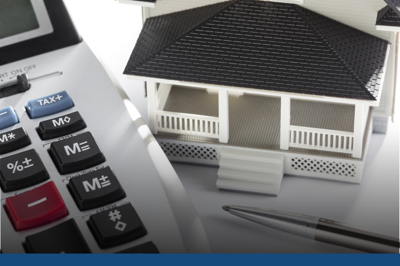 Real Estate Appraisers Calculator next to a pen and model of a house
