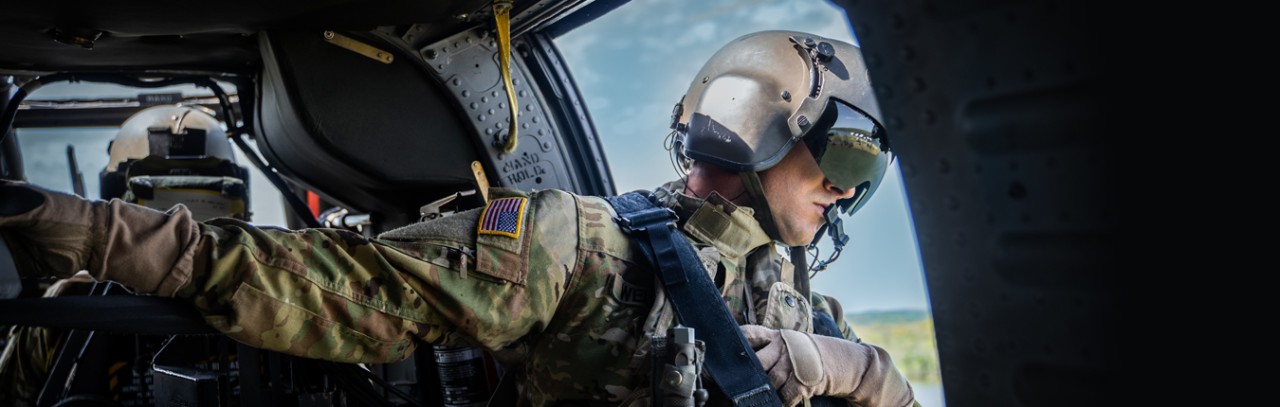 A Tennessee National Guardsmen in uniform looking out of a black hawk helicopter side door A Tennessee National Guardsmen in uniform looking out of a black hawk helicopter side door