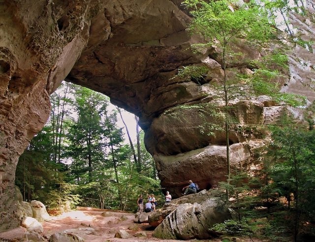 A group of hikers take lunch under the gigantic rock arch formation at Twin Arches A group of hikers take lunch under the gigantic rock arch formation at Twin Arches