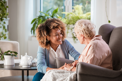 Staff member assisting elderly woman Adult Day Services
