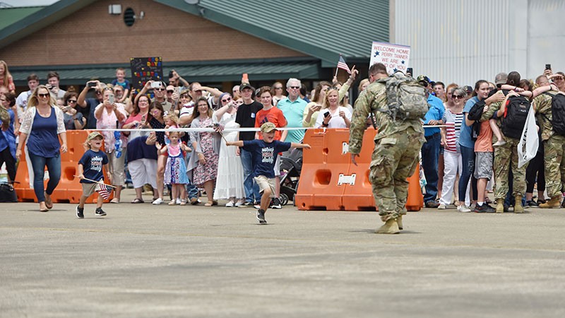 Children running on tarmac to their father, a Tennessee Soldier returning from deployment to Kosovo