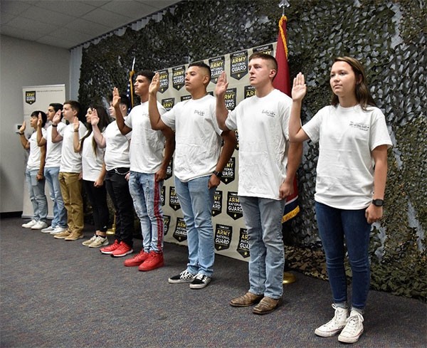 New Soldiers with the Tennessee National Guard raise their right hand and repeat the oath of enlistment with their friends and family in attendance at the Smyrna Bowling Center on July 23. (Photo by Sgt. James Bolen)