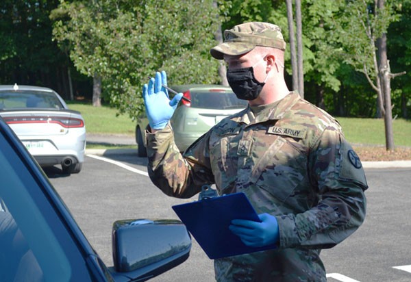Pfc. William Orton, a cavalry scout assigned to Newport’s O Troop, 4th Squadron, 278th Armored Cavalry Regiment, explains the COVID-19 vaccination process to a resident in Decatur on June 15. Orton has assisted several sites since he joined the COVID-19 Task Force in February. (Photo by Sgt. Finis L. Dailey, III)