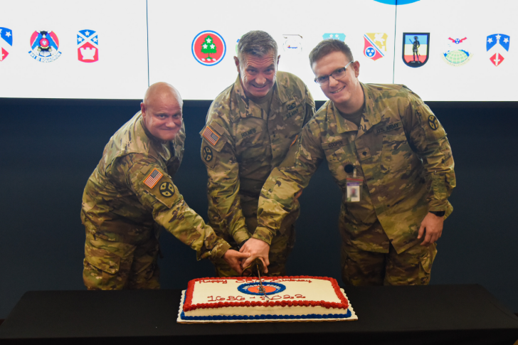 Master Sgt. Mike Avella, Maj. Gen. Jeff Holmes, and Spc. Caleb Cooper use a ceremonial saber to cut a cake celebrating the National Guard’s 386th birthday at Nashville’s Joint Force Headquarters, Dec. 13. (Photo by retired Sgt. 1st Class William Jones)