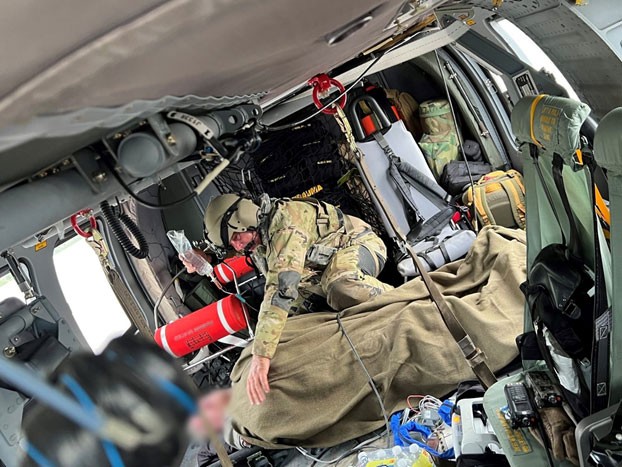 An aircrewman from the Tennessee Army National Guard comforts a patient rescued from the flooding in eastern Kentucky while being flown to a local hospital, July 28. (submitted photo)  