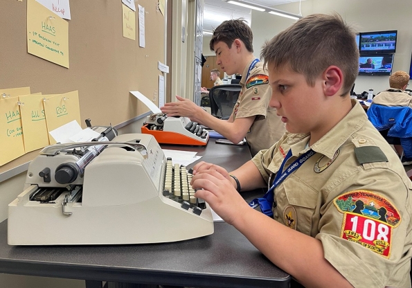 Scouts learn how to write using a manual typewriter while attending journalism merit badge at the 2nd Annual Merit Badge University hosted by the Tennessee Military Department at the Joint Force Headquarters in Nashville, April 29. (photo by Lt. Col. Darrin Haas)
