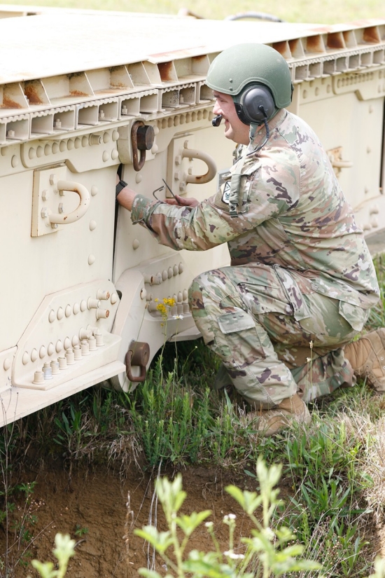 A Tennessee Army National Guard Soldier assigned to the 190th Engineer Company installs a locking pin on the bridge of an M60 Armored Vehicle Launch Bridge over a simulated flooding stream at the Volunteer Training Site in Tullahoma, Saturday, May 18. The training exercise, which focused on the company’s ability to rapidly deploy and set up the M60 bridge, was part of the unit’s ongoing preparation for potential natural disaster response missions. (U.S. Army National Guard photo by Sgt. First Class Mathieu Perry)