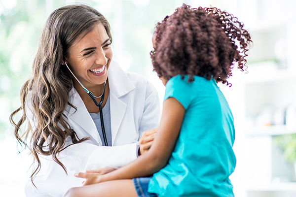 Smiling doctor checking a child.