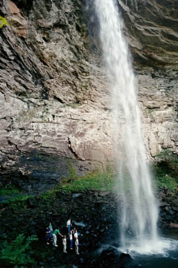 Girl scouts stand next to a large waterfall