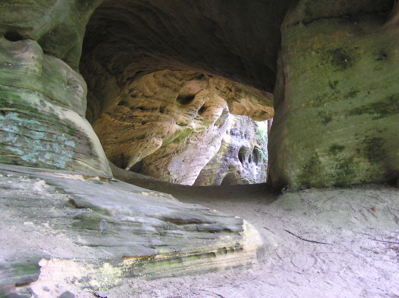 Sandy soil trail leaidng into a natural sandstone arch at Pogue creek